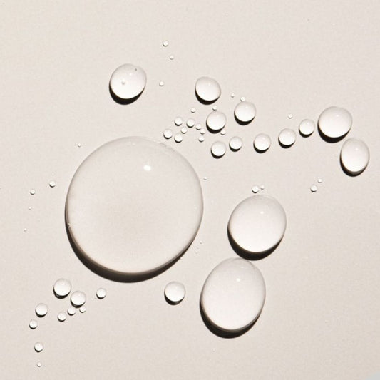 Oil droplets of various sizes scattered on a light beige surface.