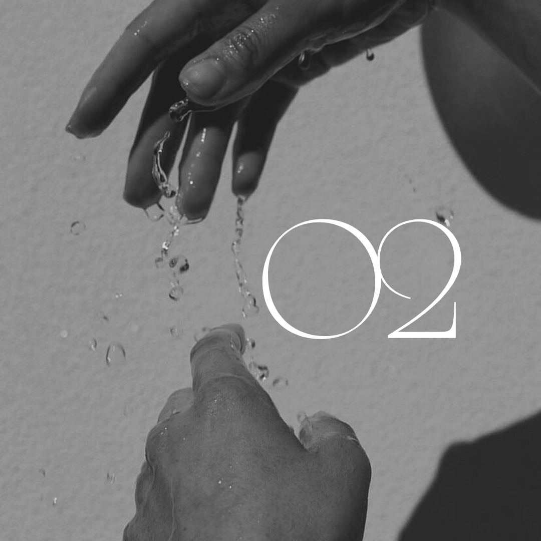 Black and white photo of hands with water droplets and the number "02".