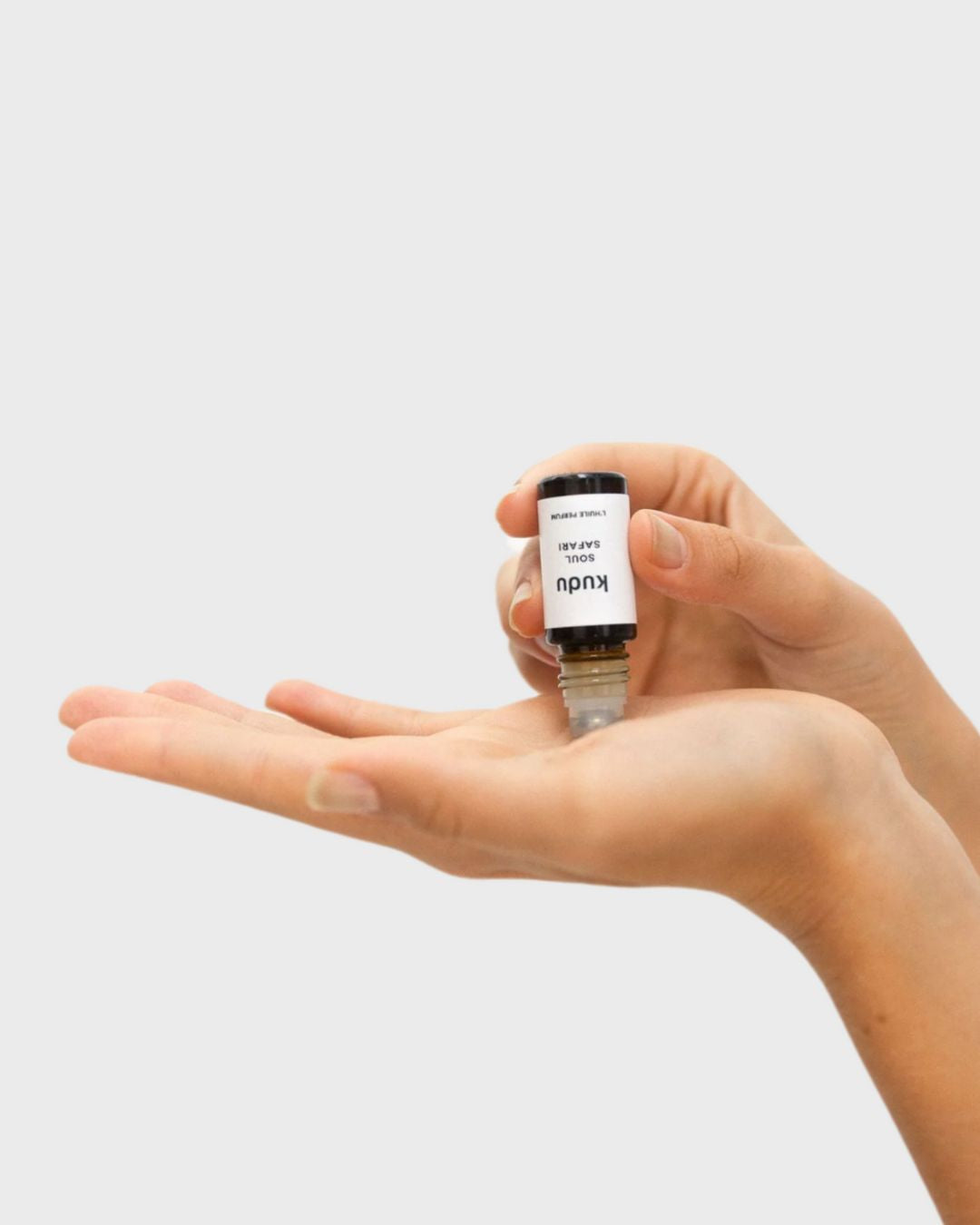 Roll-on perfume bottle labeled "Kudu Soul Safari L'Huile Parfum" with an amber rollerball glass bottle . The design is modern and minimalist.