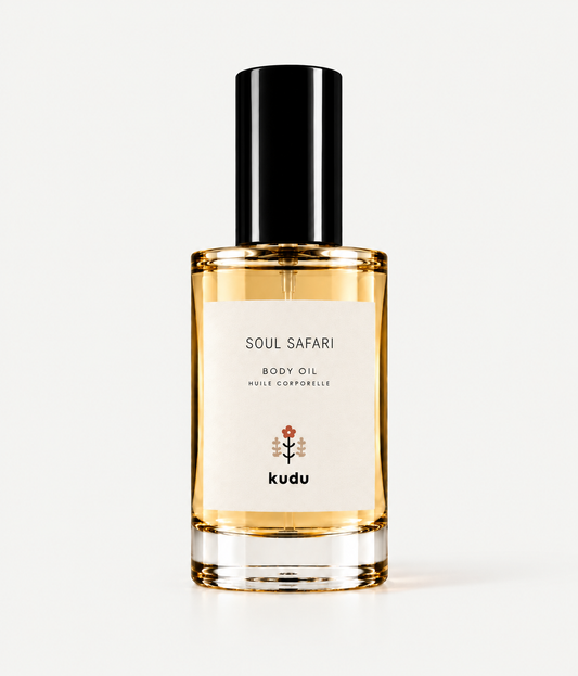A bottle of Kudu Cabana Rose Body Oil with a black cap and a cream-colored label, set against a solid light beige background.