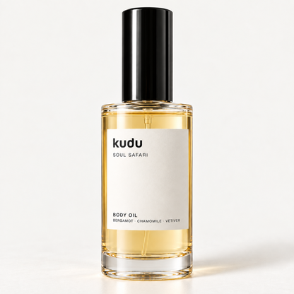 A bottle of Kudu Cabana Rose Body Oil with a black cap and a cream-colored label, set against a solid light beige background.