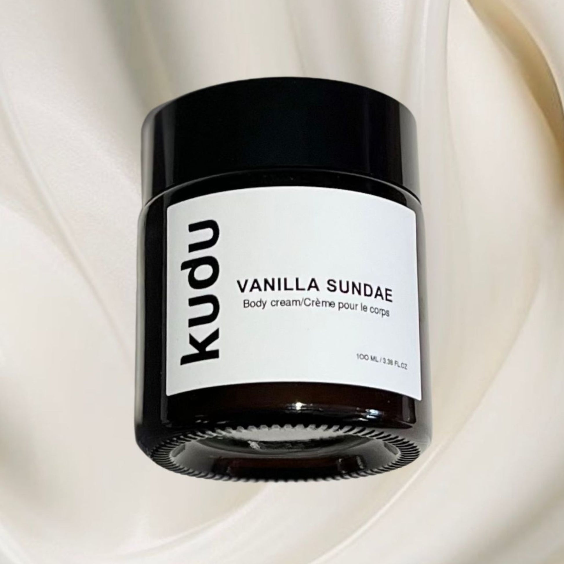 A jar of vanilla sundae ultra nourishing whipped body cream, showcasing its creamy texture and inviting label design by skincare brand Kudu Cosmetica.