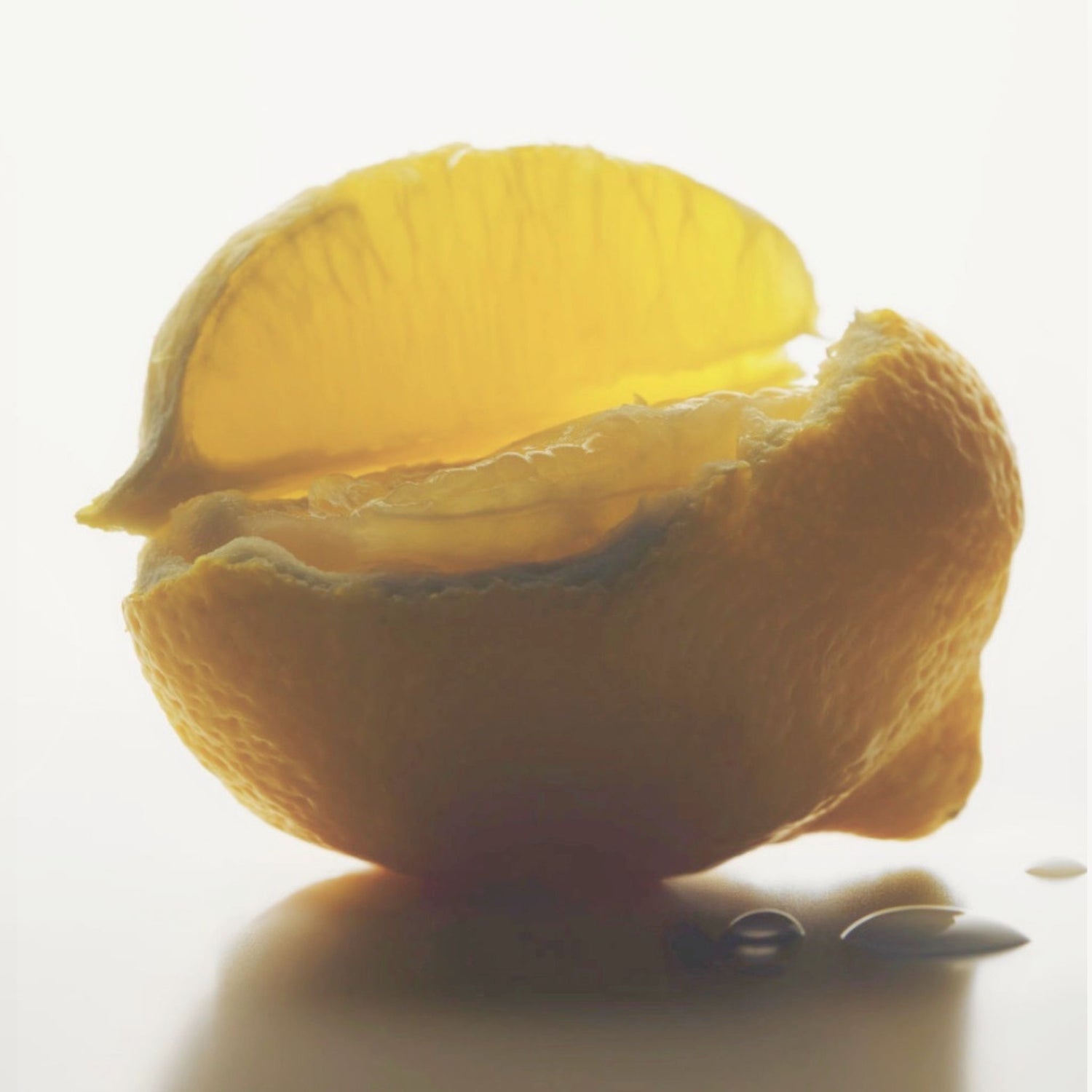 Softly lit citrus fruit with diffused glow, representing a fresh scented body cream.
