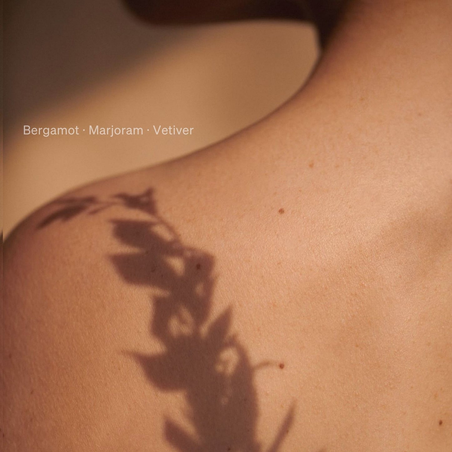 Soft focus shadow of botanical leaves across skin with fragrance notes bergamot, marjoram and vetiver for Kudu Desert Moon perfume oil