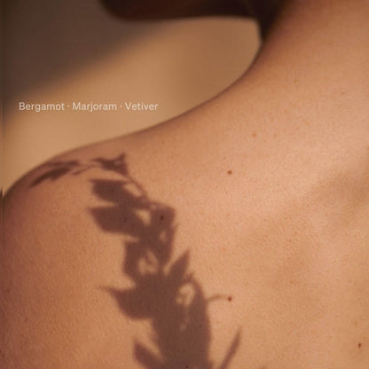 Soft focus shadow of botanical leaves across skin with fragrance notes bergamot, marjoram and vetiver for Kudu Desert Moon perfume oil