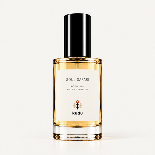 A bottle of Kudu Cabana Rose Body Oil with a black cap and a cream-colored label, set against a solid light beige background.