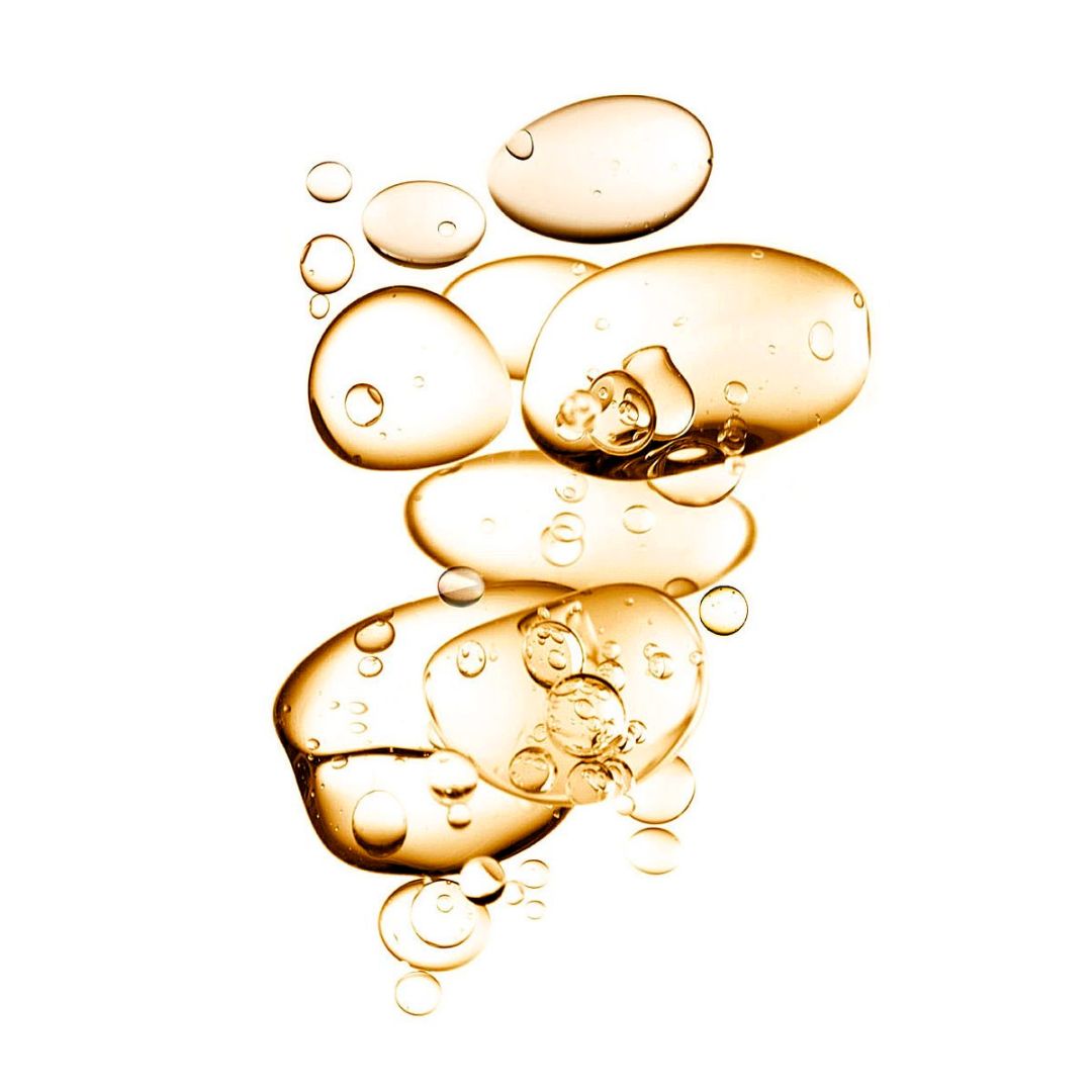 Golden oil bubbles floating against a light background.